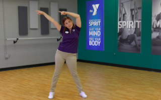 ymca instructor standing with arms pointing to the left