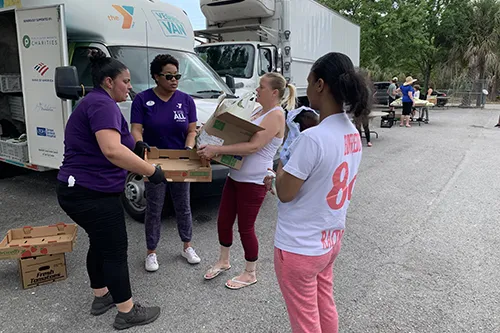 Tampa YMCA Veggie Van staff dispersing packages of produce