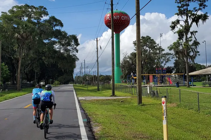 two bicyclists on road by Plant City water tower