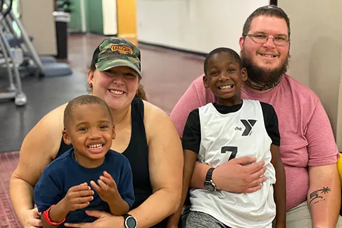family of four smiling at the camera at the New Tampa YMCA