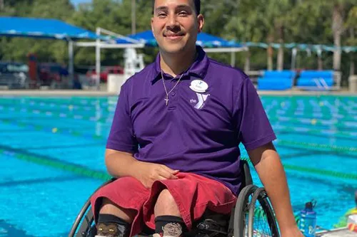 New Tampa Y staff member Gabe in a wheelchair on New Tampa Y pool deck