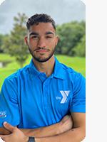 outdoor headshot of personal trainer wearing light blue YMCA polo with arms crossed