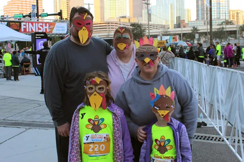 family of three adults and two kids at the 2021 Tampa YMCA turkey gobble race wearing handmade turkey masks