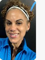 headshot of female personal trainer wearing blue YMCA polo black background