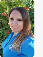 headshot of female personal trainer wearing blue YMCA polo plants in background
