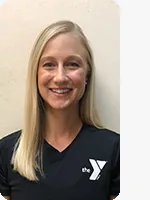 headshot of female personal trainer wearing black YMCA polo beige background