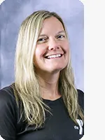 headshot of female personal trainer wearing black Y shirt with gray background