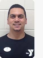 headshot of male personal trainer wearing black YMCA polo white background