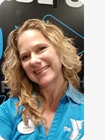 headshot of female personal trainer wearing blue YMCA polo black background