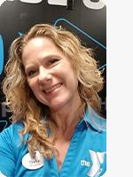 headshot of female personal trainer wearing blue YMCA polo black background