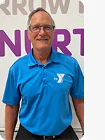 headshot of male personal trainer wearing blue YMCA polo in front of a wall with letters