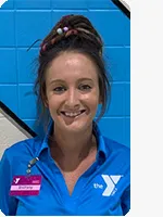 headshot of female personal trainer wearing blue YMCA polo, hair in a bun and wearing a purple name tag