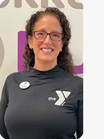 Woman with shoulder length curly brown hair wearing gray shirt and white YMCA logo headshot