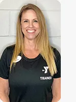 Female personal trainer wearing a black YMCA trainer shirt in front of a gray wall.