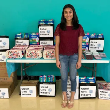 Founder Aanya Patel with dozens of donated menstrual hygiene products at the Y for her organization Global Girls Initiative.