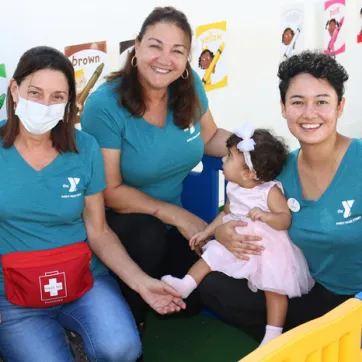 Group of three female Early Head Start staff with a baby.